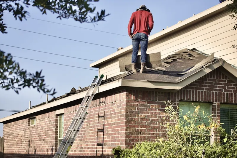 Professional roofer working on a residential roof in Colonia